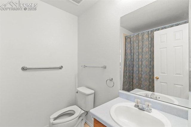 full bath with toilet, vanity, and curtained shower
