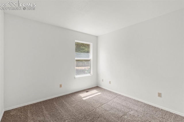 unfurnished room featuring carpet floors and baseboards