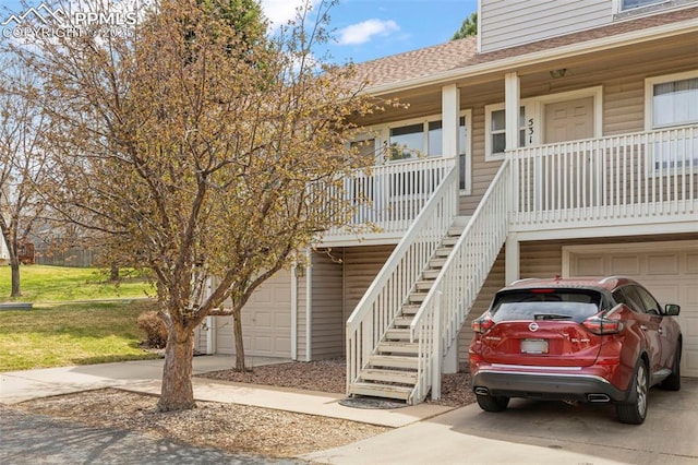 view of building exterior featuring stairway, driveway, and a garage