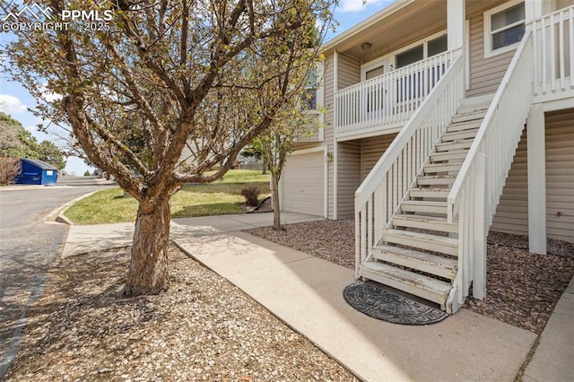 view of home's community with an attached garage and stairway