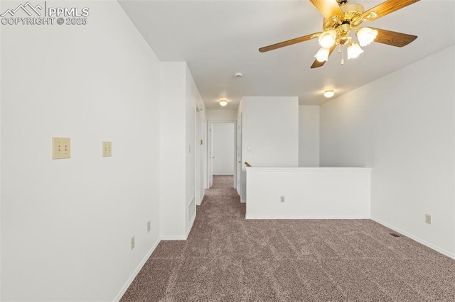 unfurnished room featuring carpet floors, a ceiling fan, and baseboards