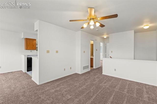 empty room with baseboards, visible vents, carpet, and ceiling fan