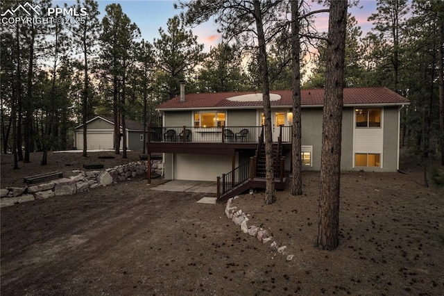 back house at dusk featuring a deck