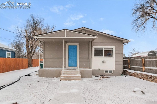 bungalow-style house with covered porch and fence