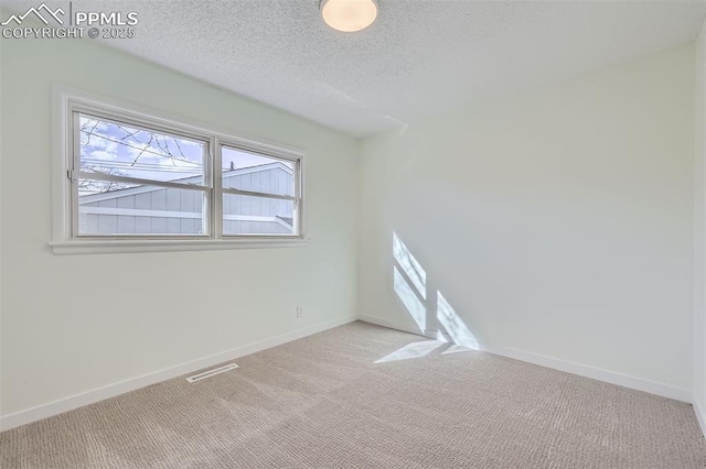 carpeted spare room featuring a textured ceiling