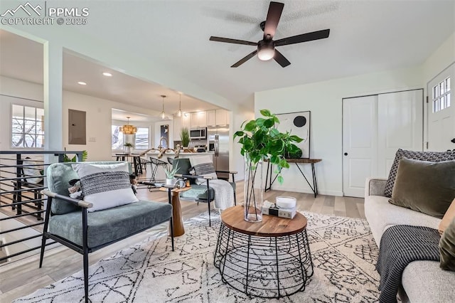 living room featuring ceiling fan, electric panel, and light hardwood / wood-style floors