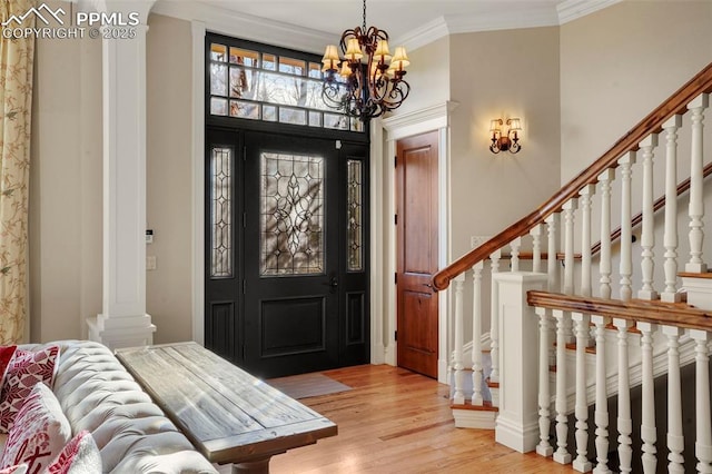 foyer with a notable chandelier, ornamental molding, and light wood-type flooring