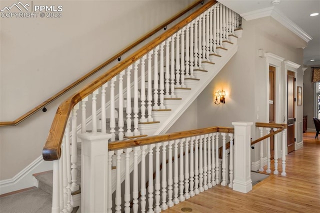 stairway with hardwood / wood-style floors and ornamental molding