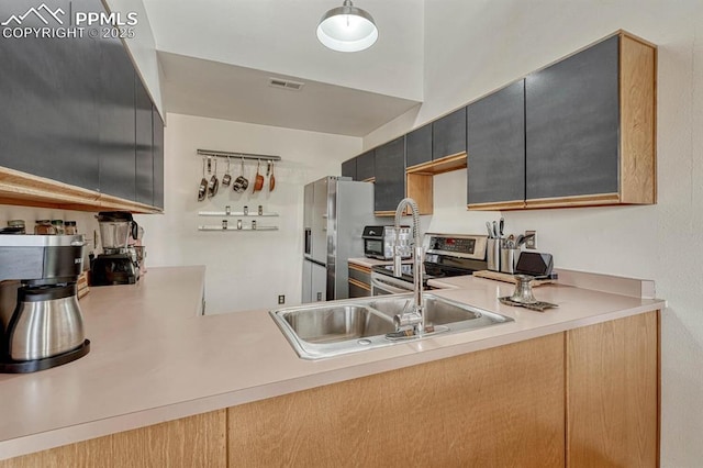 kitchen featuring stainless steel appliances, light countertops, visible vents, and a sink