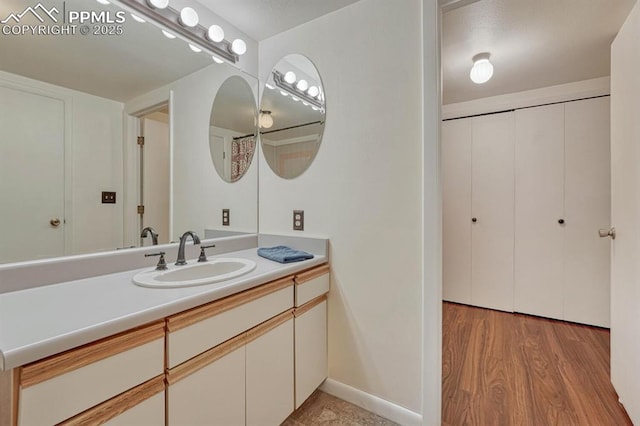 bathroom featuring vanity, baseboards, and wood finished floors