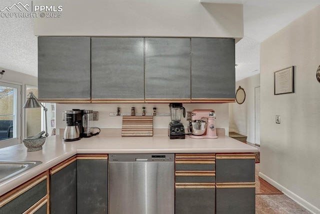 kitchen featuring a textured ceiling, baseboards, dishwasher, and gray cabinetry