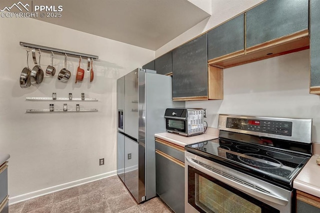 kitchen with appliances with stainless steel finishes, light countertops, and baseboards