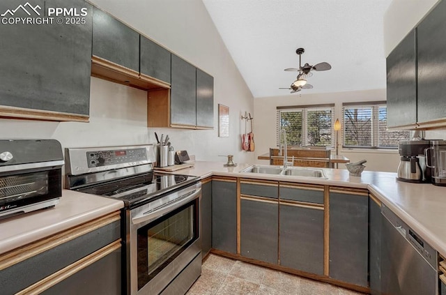 kitchen featuring light countertops, vaulted ceiling, a sink, ceiling fan, and stainless steel range with electric stovetop