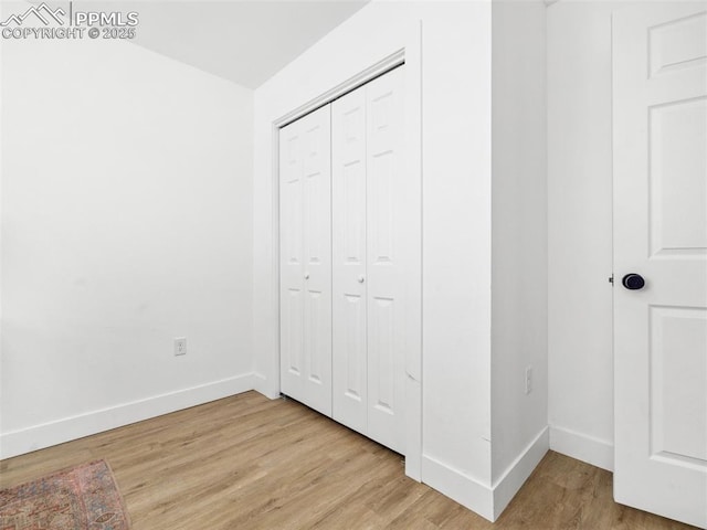 unfurnished bedroom with light hardwood / wood-style floors and a closet