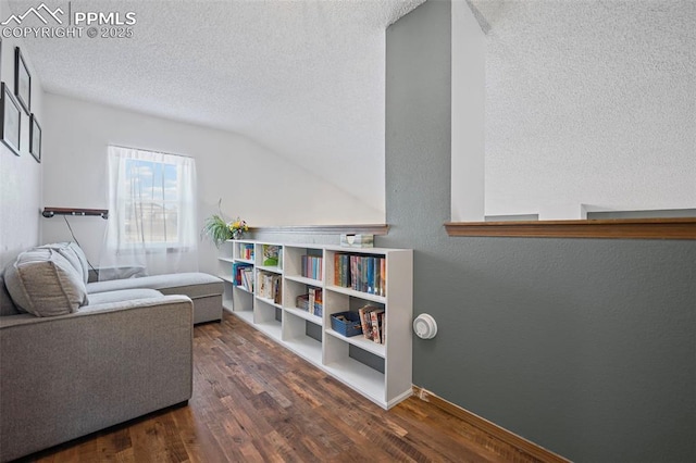 sitting room with dark wood-type flooring and a textured ceiling