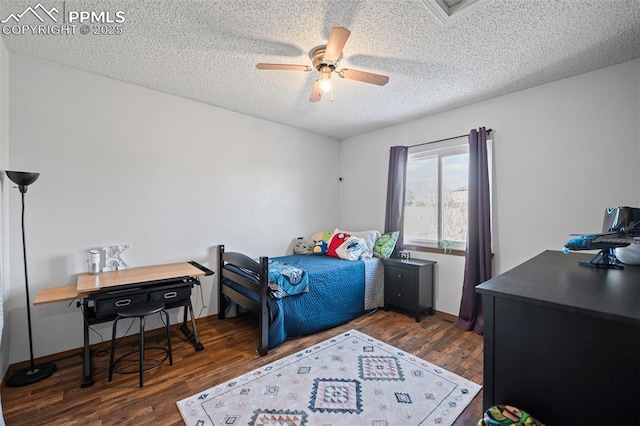 bedroom with ceiling fan, dark hardwood / wood-style flooring, and a textured ceiling