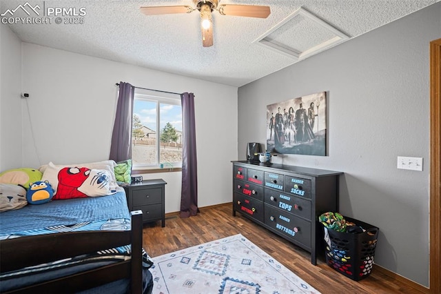 bedroom featuring dark hardwood / wood-style flooring, ceiling fan, and a textured ceiling