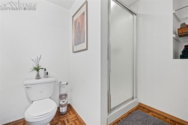 bathroom with parquet flooring, a shower with shower door, and toilet