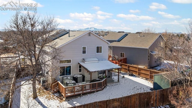 snow covered property with a deck