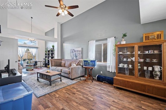 living room featuring high vaulted ceiling, dark hardwood / wood-style flooring, and ceiling fan with notable chandelier