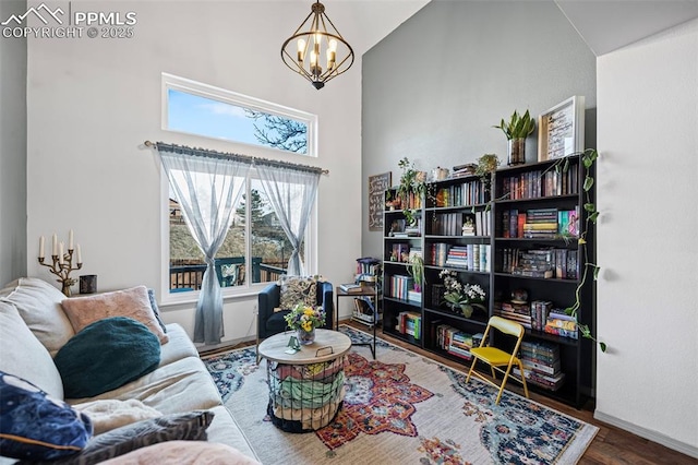 sitting room featuring an inviting chandelier, hardwood / wood-style floors, and a towering ceiling