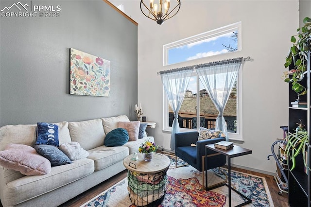 living room with a high ceiling, wood-type flooring, and a notable chandelier