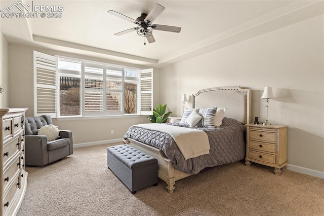 bedroom featuring ceiling fan, carpet floors, a tray ceiling, and baseboards