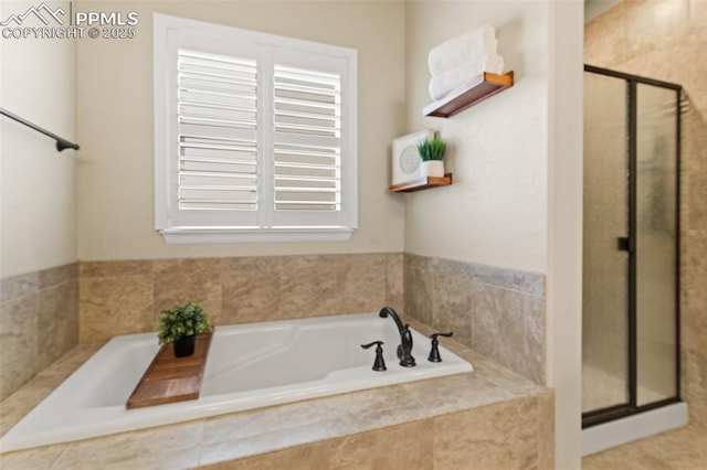 bathroom with a shower stall and a bath