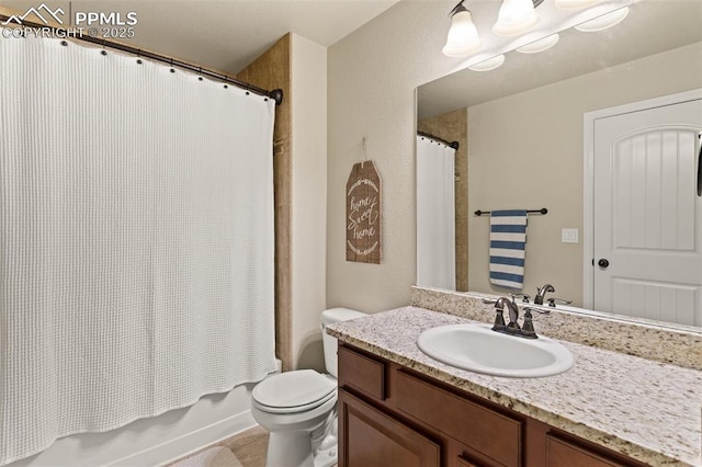 bathroom featuring toilet, shower / bath combo with shower curtain, and vanity