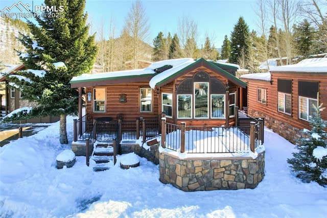 snow covered house featuring covered porch