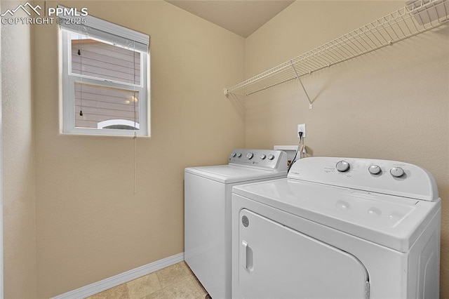 laundry area with washing machine and dryer and light tile patterned floors