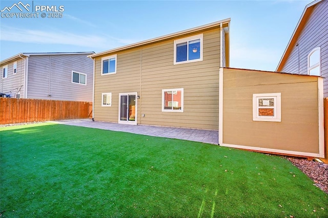 rear view of house featuring a yard and a patio