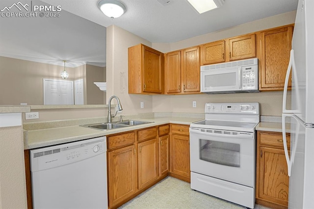 kitchen with white appliances, kitchen peninsula, and sink