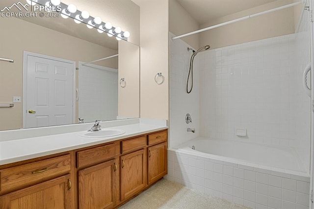 bathroom featuring tiled shower / bath and vanity