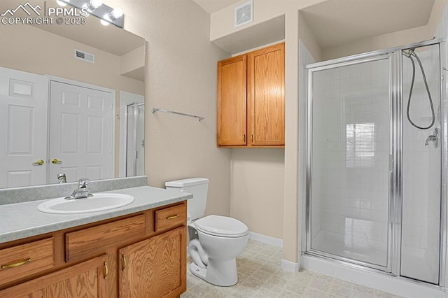 bathroom with vanity, toilet, and a shower with door