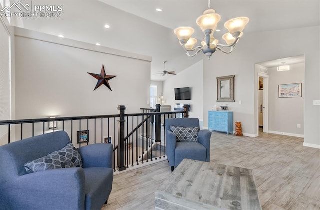 living room featuring lofted ceiling, a chandelier, and light hardwood / wood-style flooring