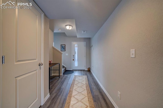 doorway featuring visible vents, baseboards, dark wood finished floors, and stairs