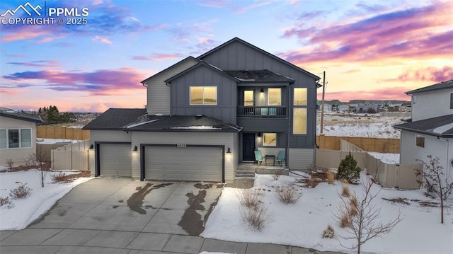 view of front of house with driveway, a garage, fence, and board and batten siding