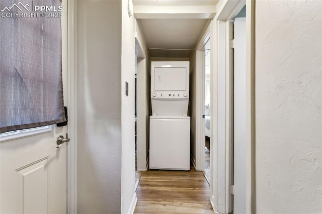 washroom featuring stacked washer / drying machine and light wood-type flooring