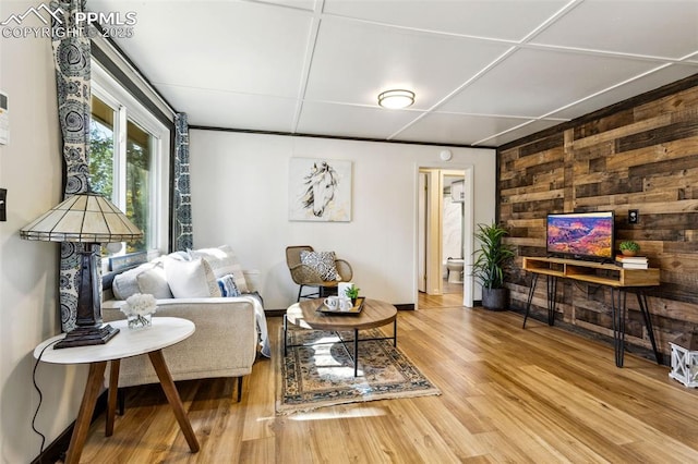 living room featuring hardwood / wood-style floors and wooden walls