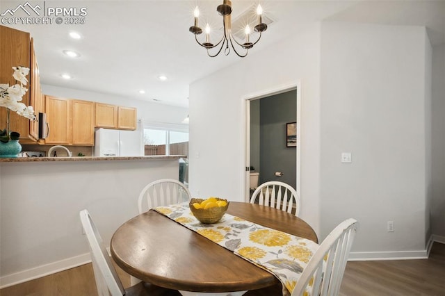 dining room with dark hardwood / wood-style flooring and a chandelier