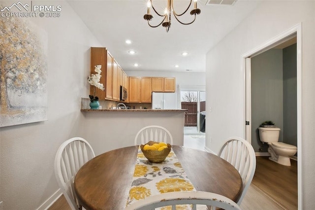 dining space featuring light hardwood / wood-style flooring and a chandelier