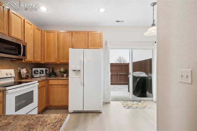 kitchen featuring white appliances, light hardwood / wood-style flooring, decorative light fixtures, and decorative backsplash