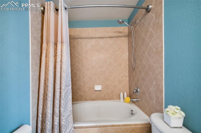 bathroom featuring shower / bath combination with curtain and toilet