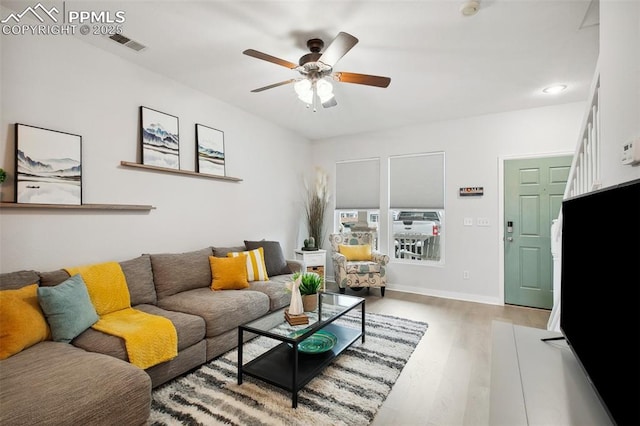 living room featuring light hardwood / wood-style flooring and ceiling fan