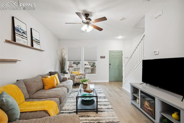 living room with ceiling fan and light wood-type flooring