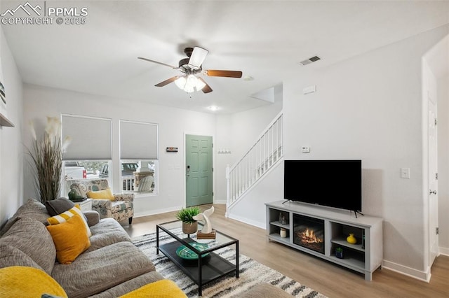 living room with ceiling fan and light hardwood / wood-style flooring