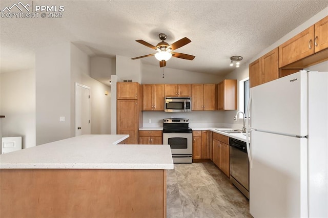 kitchen with sink, vaulted ceiling, a textured ceiling, appliances with stainless steel finishes, and ceiling fan