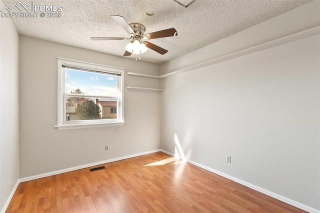 unfurnished room with ceiling fan, hardwood / wood-style flooring, and a textured ceiling