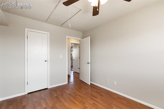 unfurnished bedroom featuring ceiling fan, dark hardwood / wood-style floors, and a textured ceiling